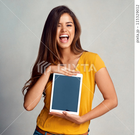 Excited woman, portrait and display with tablet screen for advertising, marketing or app on a studio background. Happy female person, model or smile for technology or presentation on mockup space Excited woman, portrait and display with tablet screen for advertising, marketing or app on a studio background. Happy female person, model or smile for technology or presentation on mockup space 115329012