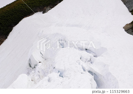 山の雪渓にできたクレバス 115329663