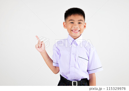 Portrait smile Asian little boy primary posing point finger to side away studio isolated white background, happy cute man kid wear school uniform plaid innocence and curiosity, back to school concept 115329976