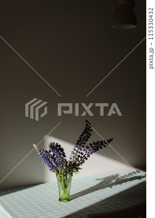 summer flowers purple lupins in vase on the table in sunlight. summer still life with blue lupines bouquet  115330432