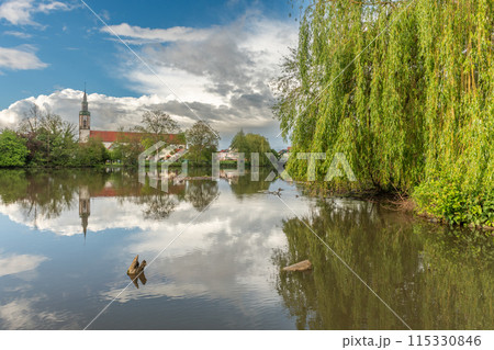 Huttenheim village reflected in a natural tree-lined river in spring. Huttenheim village reflected in a natural tree-lined river in spring. 115330846