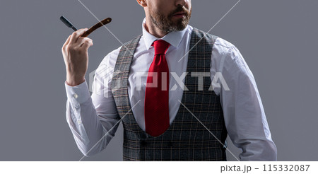 cropped bearded man barber. unshaven man barber hold blade isolated on grey background. 115332087