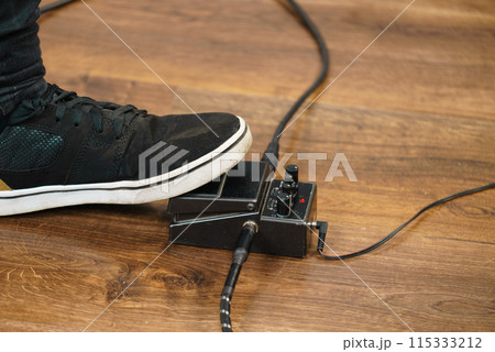 Man using guitar effects pedal 115333212