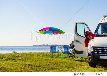 Umbrella with chairs at campervan on beach Umbrella with chairs at campervan on beach 115333240
