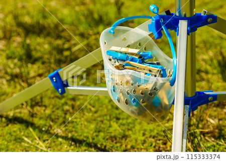 Drier and cloths pins in bucket used for hanging wet laundry 115333374