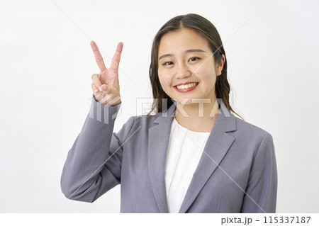 ピースサインをする若いビジネスウーマン 白背景 ピースサインをする若いビジネスウーマン 白背景 115337187