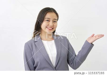 手のひらで右側を指す若いビジネスウーマン　白背景 115337193