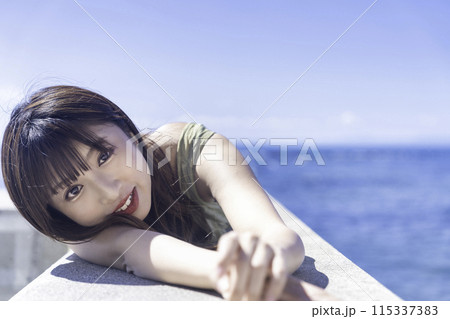 防波堤に寝転んで海を満喫する若い女性 防波堤に寝転んで海を満喫する若い女性 115337383