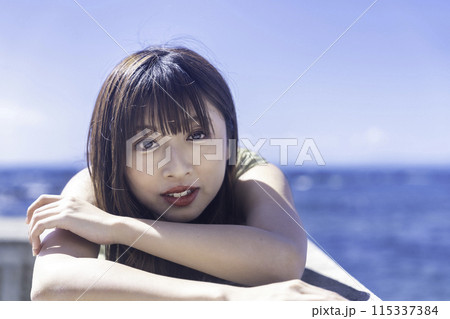 防波堤に寝転んで海を満喫する若い女性 115337384
