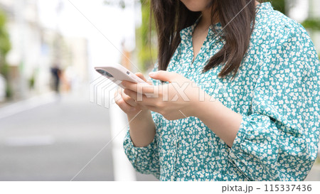 街角でスマホを使用する若い女性 115337436