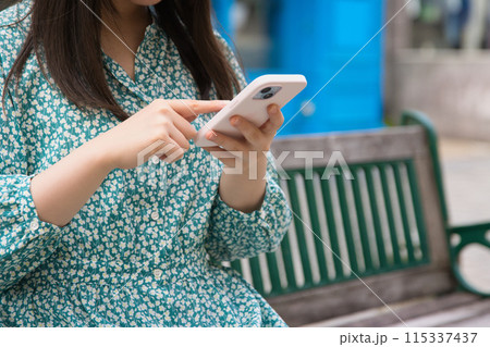 街角でスマホを操作する若い女性 115337437