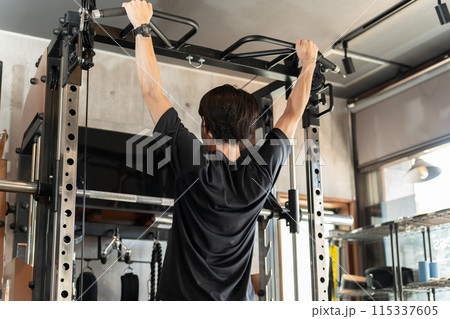 ジムのパワーラックで懸垂・チンニングをする男性（背中トレーニング・筋トレ・ワークアウト） 115337605