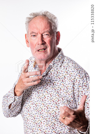 A senior man is expressing various emotions during a professional photoshoot in a studio A senior man is expressing various emotions during a professional photoshoot in a studio 115338820