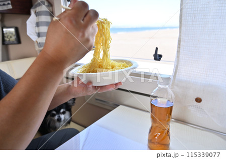 キャンピングカーで海を見ながらざるラーメンを食べる男性 115339077