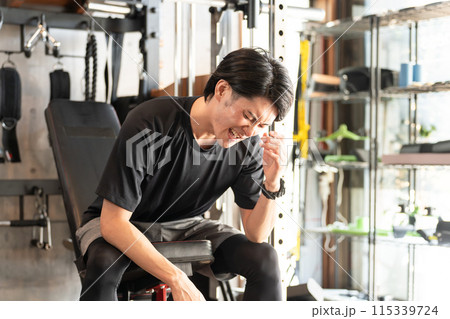 スポーツジムで疲労が蓄積した若いアスリート・アジア人男性(オーバーワーク・ハードトレーニング） 115339724