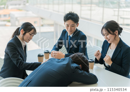 落ち込む・悲しむ・意気消沈する男性ビジネスマンを慰めるビジネスウーマン（失敗・ミス・トラブル） 115340534