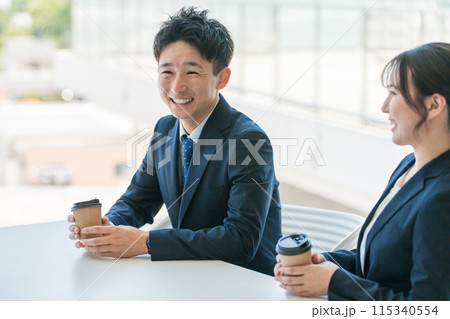 オフィスの休憩スペースで談笑するビジネスマン男女 オフィスの休憩スペースで談笑するビジネスマン男女 115340554