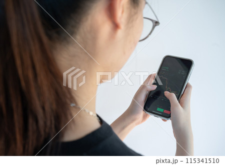 Woman checking Bitcoin price chart on digital exchange on her smartphone. A cryptocurrency exchange is an online marketplace where users buy, sell, and trade. Woman checking Bitcoin price chart on digital exchange on her smartphone. A cryptocurrency exchange is an online marketplace where users buy, sell, and trade. 115341510