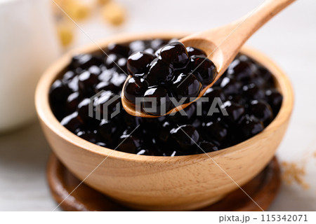 Black tapioca pearls or boba in wooden bowl with spoon, Ingredient in bubble tea 115342071
