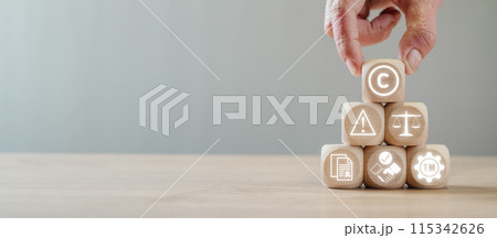Copyright or patent concept, Hand holding wooden block on desk with copyright icon on virtual screen, Author rights and patented intellectual property, copyleft trademark license. 115342626