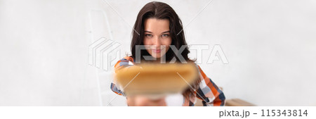 Young Woman Holding Paintbrush Ready for Home Makeover 115343814