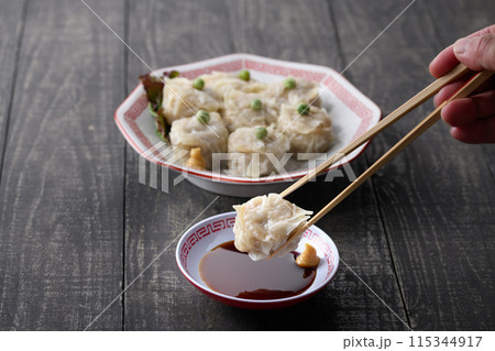 蒸し料理 焼売(しゅうまい)をタレにつける 蒸し料理 焼売(しゅうまい)をタレにつける 115344917