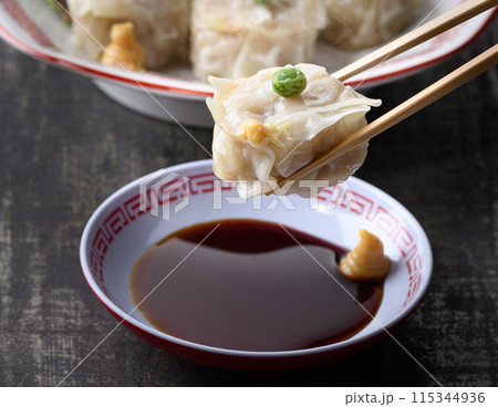 蒸し料理 焼売(しゅうまい)をタレにつける 蒸し料理 焼売(しゅうまい)をタレにつける 115344936