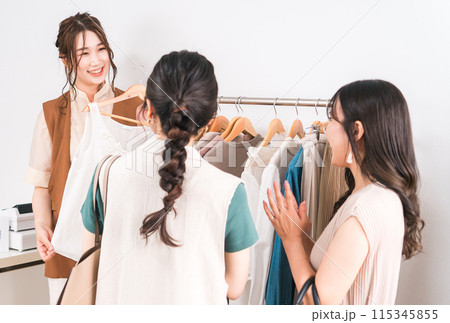 女性買い物客に洋服・トップスをおすすめする女性ショップ店員 女性買い物客に洋服・トップスをおすすめする女性ショップ店員 115345855