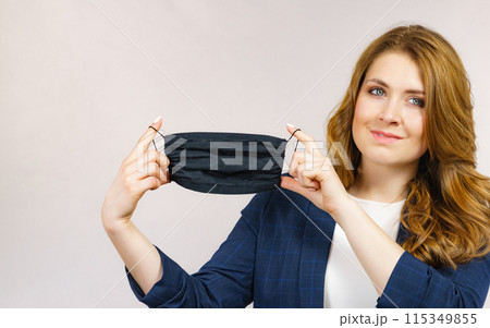 Woman shows black protective face mask. Woman shows black protective face mask. 115349855