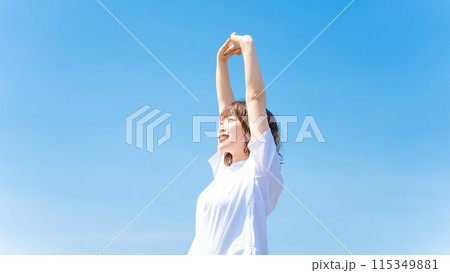 夏の青空と白いTシャツを着た笑顔の女性 115349881