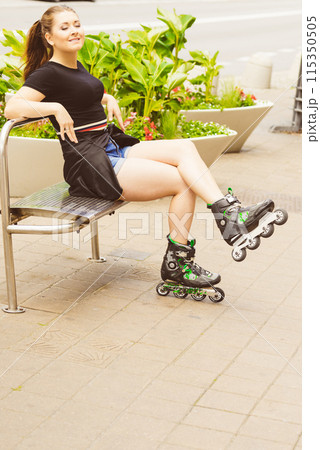 Young woman sitting wearing roller skates 115350505