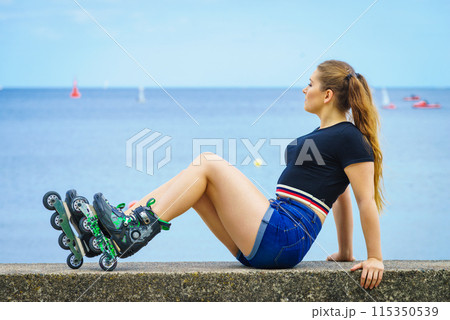 Girl wearing roller skates on seaside Girl wearing roller skates on seaside 115350539