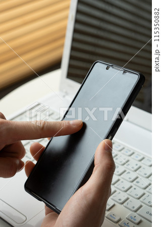 ビジネス素材　スマホを打つイメージ 115350882