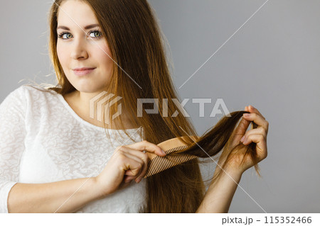 Happy woman brushing her hair 115352466