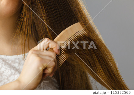 Happy woman brushing her hair Happy woman brushing her hair 115352569
