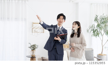 部屋の案内をするビジネスマン 115352955