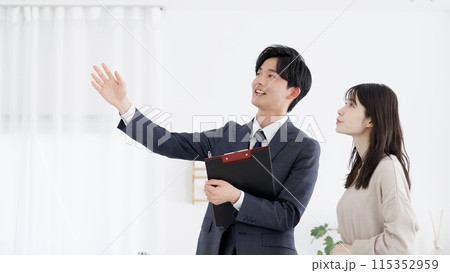 部屋の案内をするビジネスマン 115352959