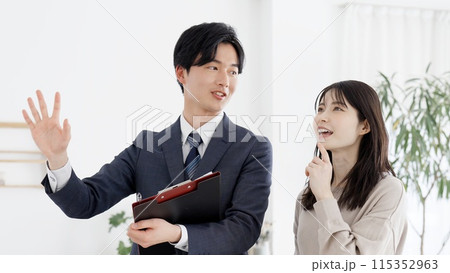 部屋の案内をするビジネスマン 115352963