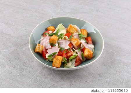 Salad with spinach, cheese, ham, grapefruit and balsamic sauce on a wooden rural background. Top view. Close-up. 115355650