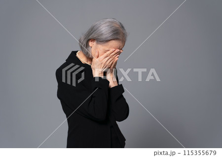 顔を覆う喪服のシニア女性　 115355679
