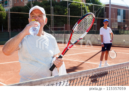 Tennis player drink water on tennis court 115357059