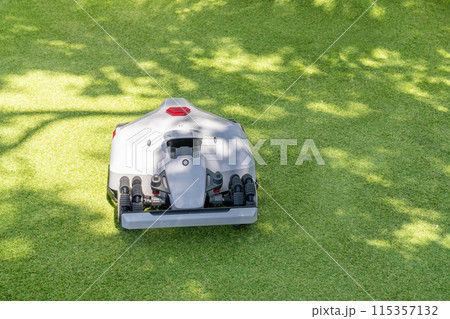 Autonomous robot lawnmower on a green field. Autonomous robot lawnmower on a green field. 115357132