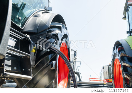 Electric agricultural tractor with connected charging cable. Concept. 115357145