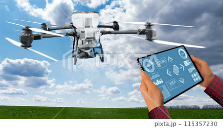 Farmer with tablet controls spreading agricultural drone that spreads fertilizer. Smart farming and precision agriculture. Farmer with tablet controls spreading agricultural drone that spreads fertilizer. Smart farming and precision agriculture. 115357230