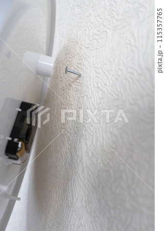 wall clock is placed on nail driven into wall 115357765