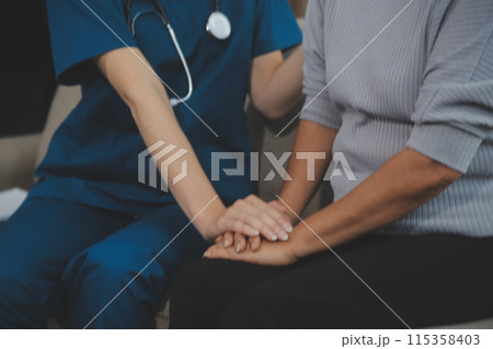 Female caregiver doing regular check-up of senior woman in her home. 115358403