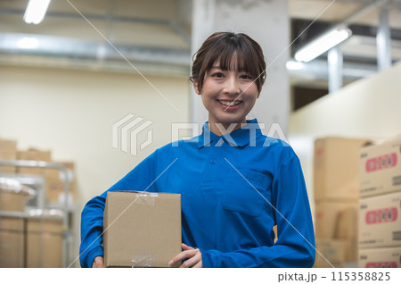 倉庫で段ボールを持つ若い女性作業員 115358825