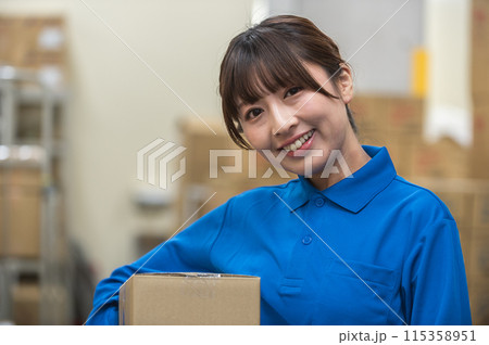 倉庫で段ボールを持つ若い女性作業員 倉庫で段ボールを持つ若い女性作業員 115358951