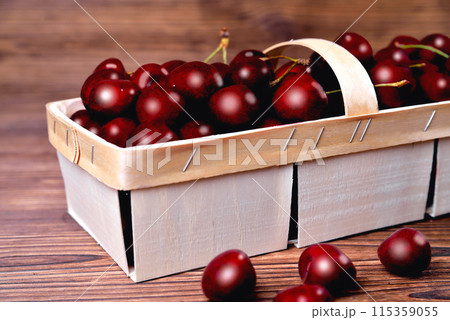 Ripe natural cherries, sweet cherries in a birch bark basket on a wooden background, 115359055