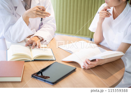 勉強する看護師と医者の手元 115359388
